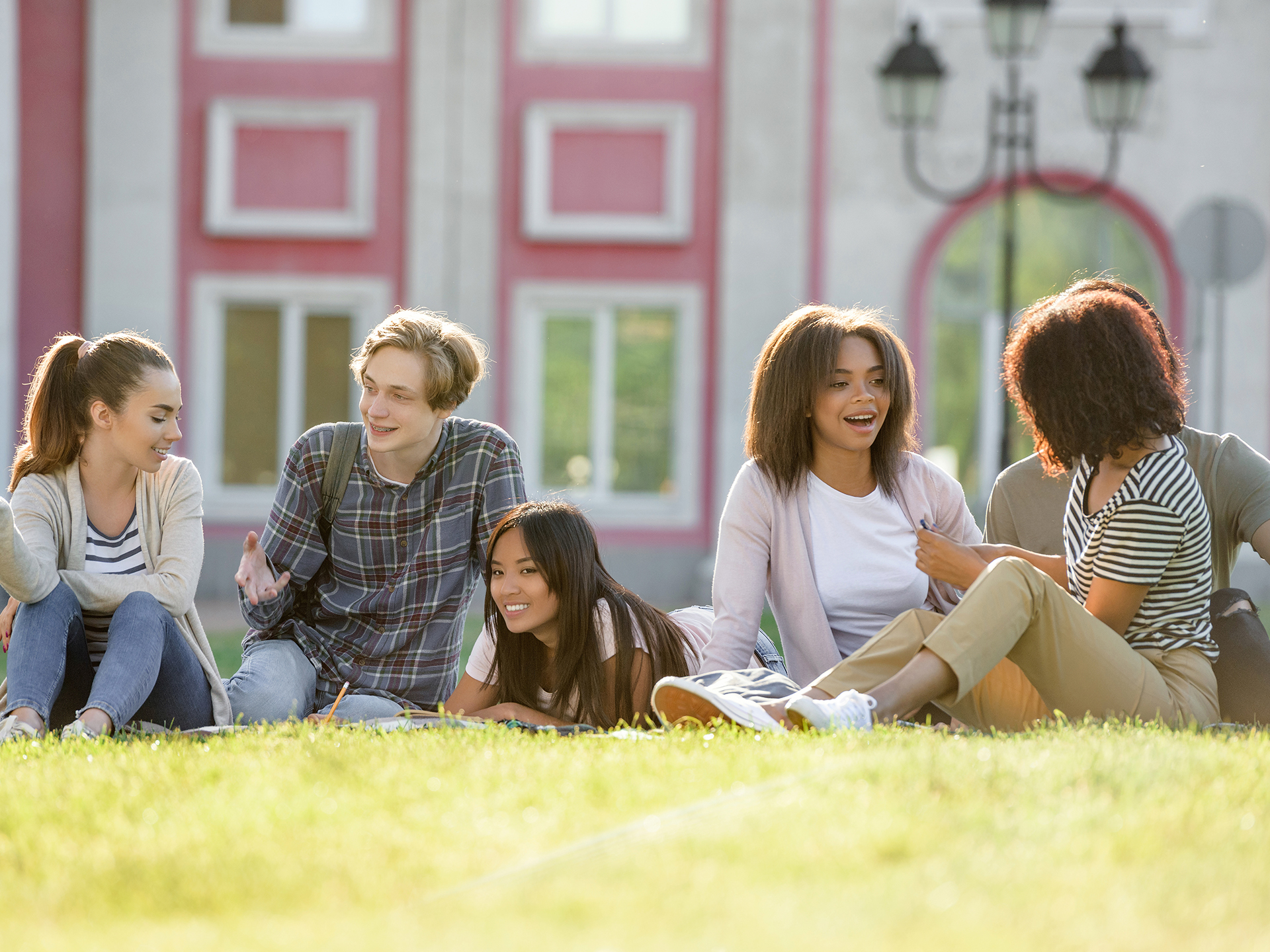 Group of university students sitting on lawn. Image by drobotdean on Freepik