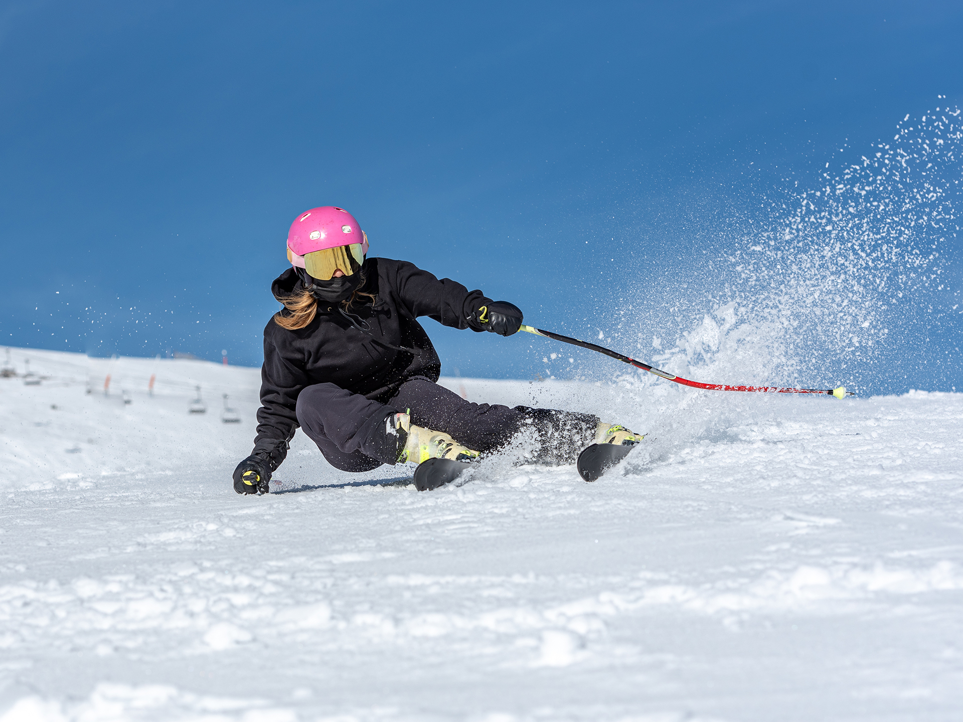 Woman carving on ski slope with pink helmet. Image by wirestock on Freepik