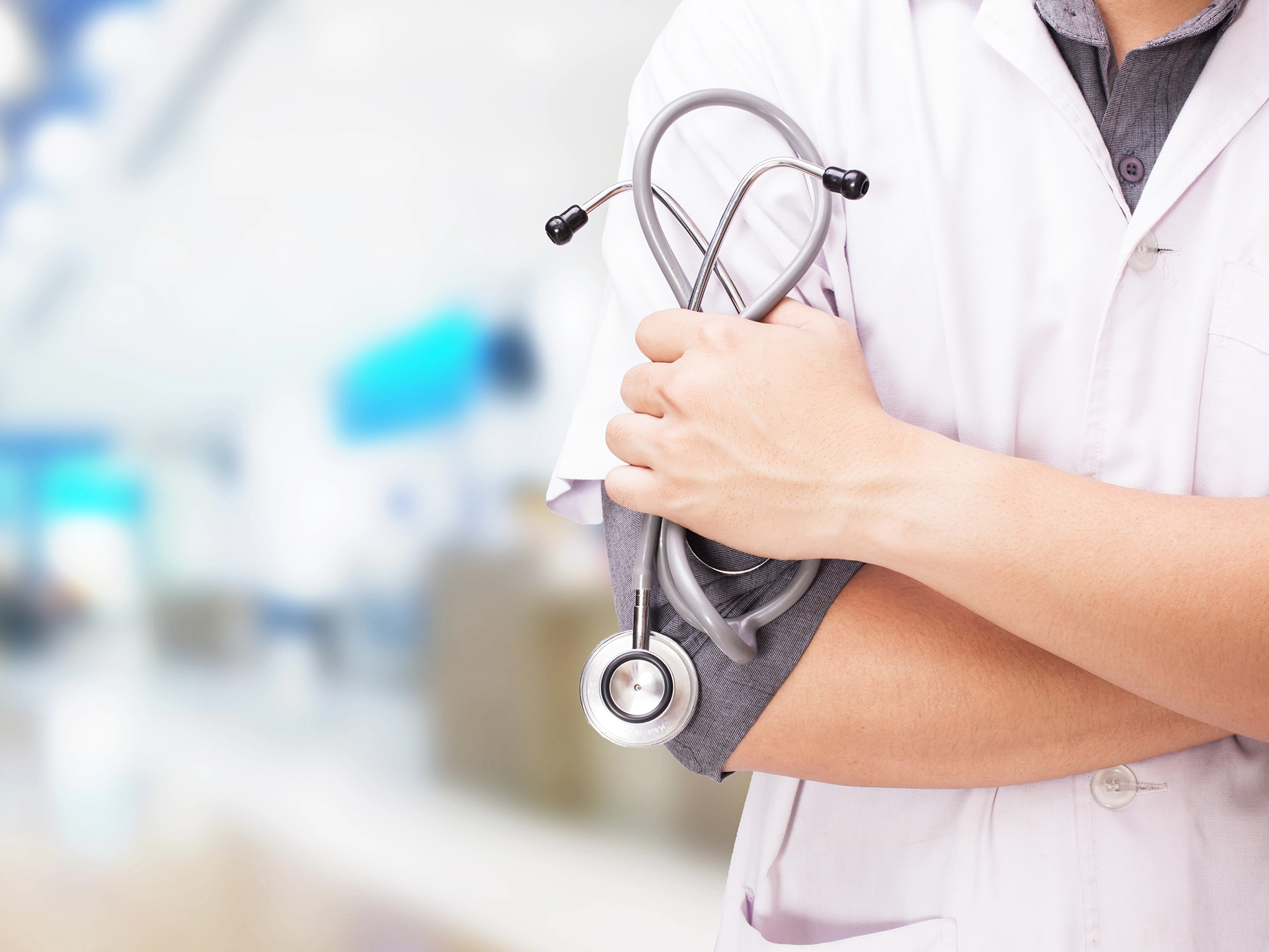 Doctor in white coat holding stethoscope in one hand while crossing arms - Image by snowing on Freepik
